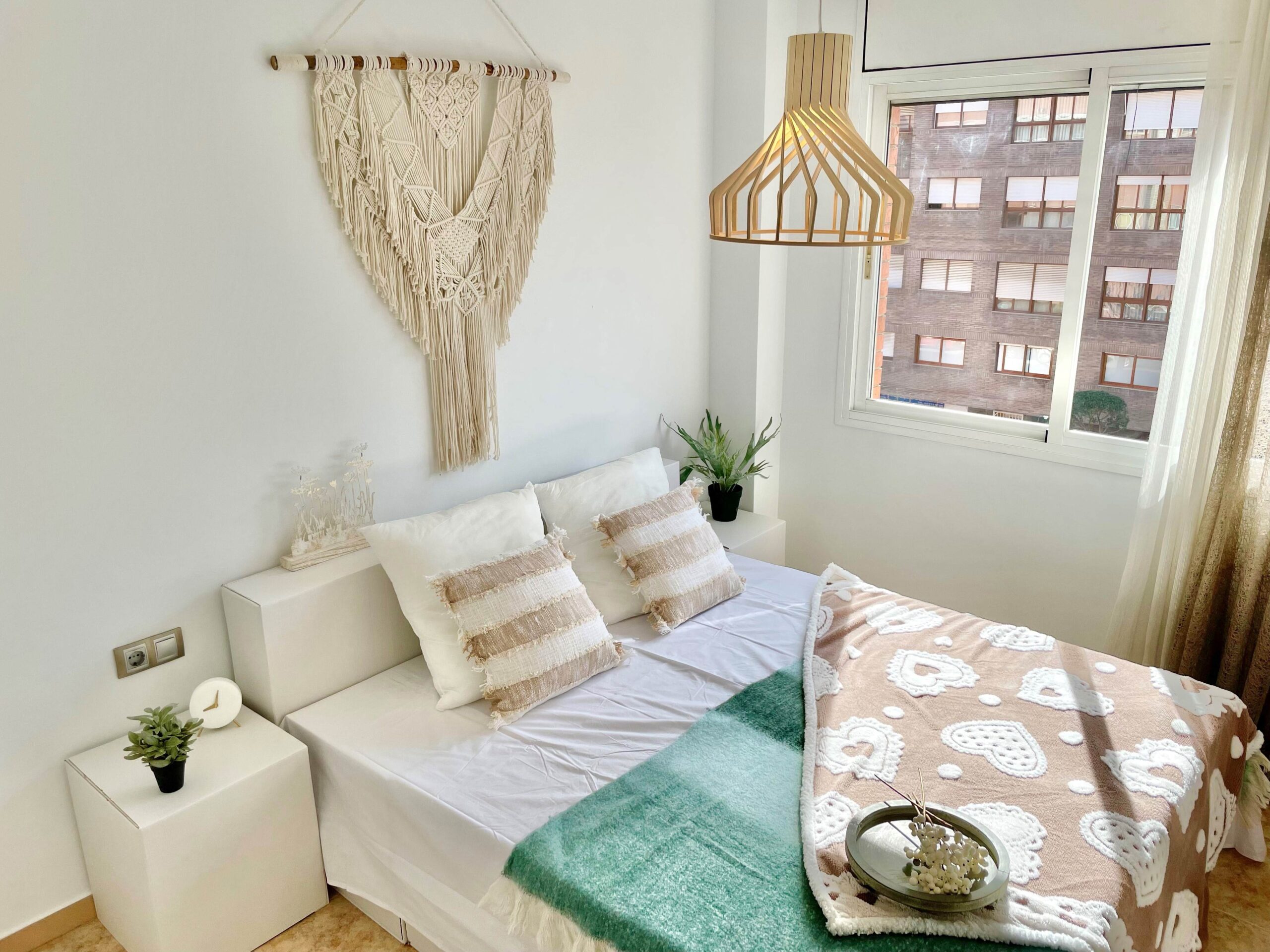 Conjunto de cama de cartón, con mesitas de noche y cabecera y decoración contemporánea para home staging.
